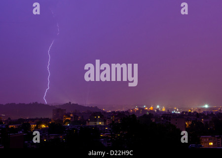 Blitz trifft die Stadt an einem regnerischen Abend Stockfoto