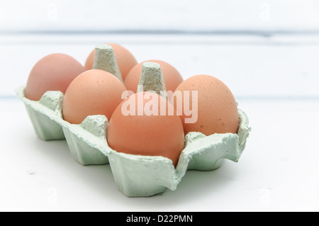 Sechs Eiern sitzen in einem grünen Karton auf der Arbeitsfläche der Küche. Stockfoto