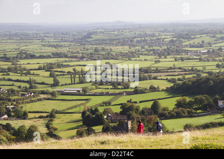 Zwei Menschen zu Fuß auf Mendip Hills mit Blick auf Glastonbury Tor. Stockfoto