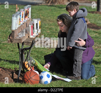 Newtown, Connecticut, USA - Amy Collins und ihr Sohn, Andrew, 5, Zeichnungen und Kerzen außerhalb der Hl. Rosa von Lima Kirche in Newtown. Sie sind von Newtown. Viele Bereich Bewohner aus der Gegend besuchten die Kirche als Gemeinschaft versucht, um sich mit dem schießen Massaker an der Grundschule von Sandy Hook gestern kommen. Der Schütze tötete Adam Lanza 20 Erstklässler und sechs Erwachsene in Sandy Hook Elementary School in Newtown in einer Masse schießen Spree. Stockfoto