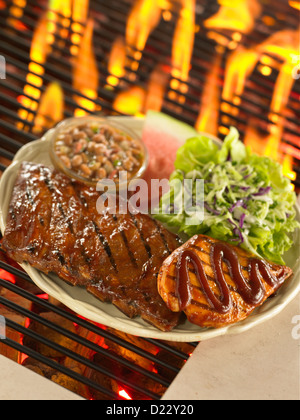 Barbecue Rippchen und Huhn auf Grill mit Pinto-Bohnen und Krautsalat Stockfoto