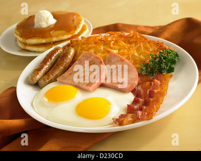 Ei-Wurst-Schinken und Speck Frühstück serviert mit Bratkartoffeln und Pfannkuchen Stockfoto