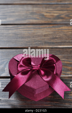 Herzförmige rosa Valentinstag-Geschenk-Box auf hölzernen Hintergrund. Stockfoto