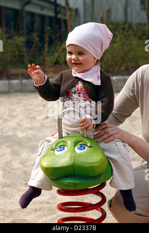 Berlin, Deutschland, ein kleines Mädchen sitzt auf einem schaukelnden Tier Stockfoto