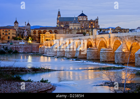 Römische Brücke über den Fluss Guadalquivir und die Mezquita (Moschee) in der Dämmerung in der Stadt Cordoba, Andalusien, Spanien. Stockfoto