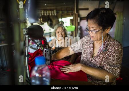 13. Januar 2013 arbeitet in ihrem Laden im Stadtteil Bang Luang Bangkok - Bangkok, Thailand - eine Frau als Näherin. Stadtteil Bang Luang Linien Khlong (Kanal) Bang Luang in der Thonburi-Sektion von Bangkok auf der westlichen Seite des Chao Phraya Flusses. Es wurde Ende des 18. Jahrhunderts von König Taksin dem großen gegründet, nachdem die Birmanen die siamesische Hauptstadt Ayutthaya entlassen. Die Nachbarschaft, wie die meisten von Thonburi, ist relativ unerschlossen und noch Kreuz und quer durchzogen von den Kanälen, die einmal Bangkok berühmt gemacht. Es ist nun ein beliebter Tagesausflug vom Zentrum von Bangkok und bietet einen Einblick in das, was Stockfoto