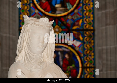 Schweiz, Basel. Die historische Kirche am Münsterplatz, Innenraum. Religiöse Statue vor der Glasfenster. Stockfoto