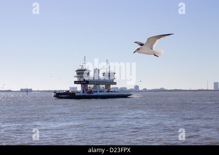 Fähre Schiff John W. Johnson zieht ins Dock in Port Bolivar, TX. Galveston, TX ist im Hintergrund sichtbar. Stockfoto