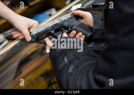 Ein Kunde interagiert mit einer Pistole auf einen Waffenladen. Stockfoto