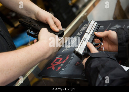 Ein Kunde interagiert mit einer Pistole auf einen Waffenladen. Stockfoto