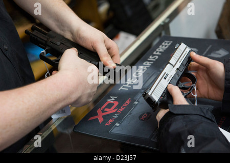 Ein Kunde interagiert mit einer Pistole auf einen Waffenladen. Stockfoto