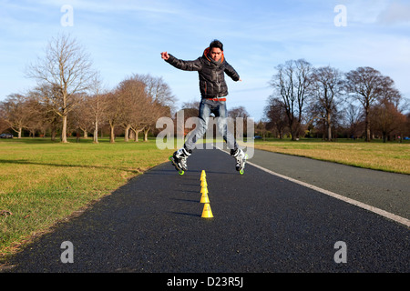 Ein asiatischer Mann führte einen Trick beim Freestyle-Slalom Training im Phoenix Park, Dublin, Irland. Stockfoto