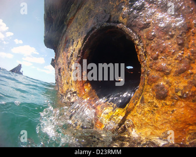 Meerwasser Gießen aus Bullauge gestrandeten Schiff Dünung vorbei, Tangalooma Wracks, Moreton Bay Marine Park, Australien Stockfoto