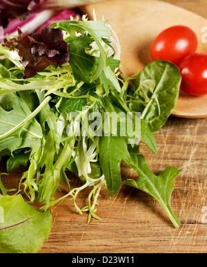Frischen Salatblättern und Cherrytomaten auf ein Schneidebrett Stockfoto