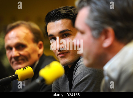 Geschäftsführer des Fußball-Bundesligisten Borussia Dortmnd (BVB), Hans-Joachim Watzke (L) und Sportdirektor des BVB, Michael Zorc (R) präsentieren die Club Neuanschaffung Nuri Sahin (C) auf einer Pressekonferenz in Dortmund, Deutschland, 11 Jauary 2013. Nuri Sahin zu Real Madrid nach der Bundesliga-Saison 2010/2011 übertragen, wurde dann auf Aloan Zauber von Real Madrid zum FC Liverpool und jetzt zurück nach Dortmund. Foto: DANIEL NAUPOLD Stockfoto