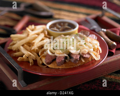 Offenen konfrontiert Steak Sandwich garniert mit gegrillten Zwiebeln und Käse geschmolzen und serviert mit Pommes frites Stockfoto