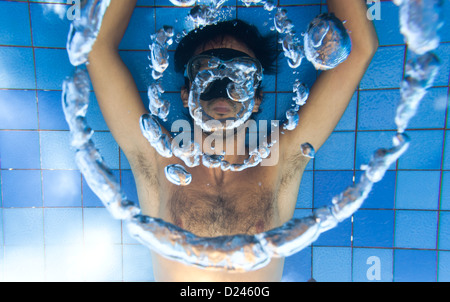 Mann, der Blase Ringe unter Wasser im pool Stockfoto