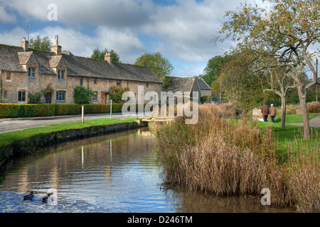 Reihe von Cotswold Hütten auf einem Fluss, England Stockfoto