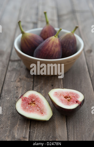 Feigen in einer Schüssel auf einem hölzernen Hintergrund. Stockfoto