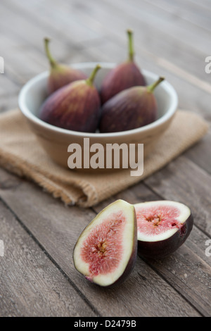 Feigen in einer Schüssel auf einem hölzernen Hintergrund. Stockfoto