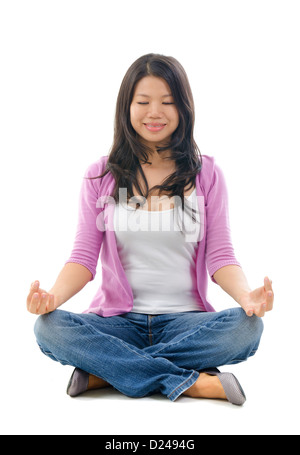 Ruhig südostasiatischen Chinesin in Yoga Lotus Pose sitzt. Voller Körper auf weißem Hintergrund. Stockfoto