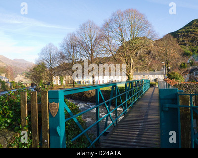 Beddgelert Gwynedd North Wales Blick über Glaslyn Fußgängerbrücke über den Fluss in das historische Dorf Stockfoto
