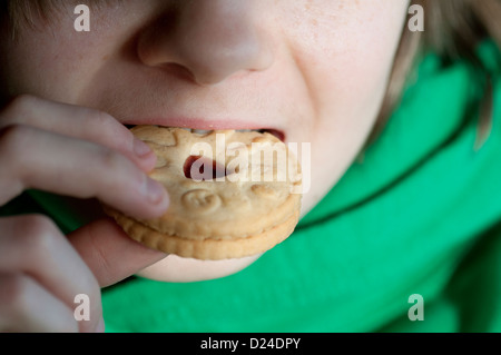 männliche junge Jammie Dodger Keks essen Stockfoto