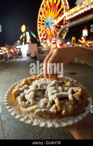 Person Trichter Kuchen essen genießt den Vergnügungspark an der Maryland State Fair, Timonium MD Stockfoto