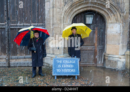 Cambridge UK 14. Januar 2013.  Träger Schutz vor Schnee unter Sonnenschirmen draußen Trinity College in Cambridge.  Dicken Schnee fiel im Laufe des Nachmittags in East Anglia nach ein Licht über Nacht abstauben.  Weitere dürften Kälte und Schneedusche in den nächsten zwei Tagen. Stockfoto