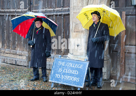 Cambridge UK 14. Januar 2013.  Träger Schutz vor Schnee unter Sonnenschirmen draußen Trinity College in Cambridge.  Dicken Schnee fiel im Laufe des Nachmittags in East Anglia nach ein Licht über Nacht abstauben.  Weitere dürften Kälte und Schneedusche in den nächsten zwei Tagen. Stockfoto