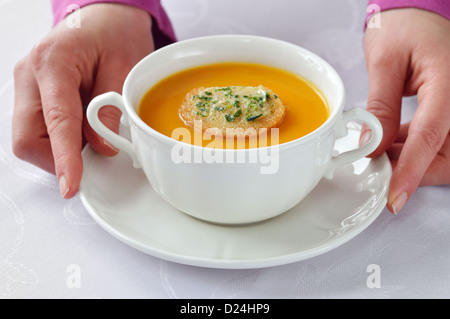 Haben wir hausgemachte geröstete Kürbissuppe in weiße Schüssel auf weißes Tischtuch. Stockfoto