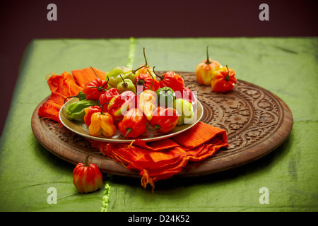 Eine Platte von Scotch Bonnet Peppers auf einem geschnitzten Holzbrett Stockfoto