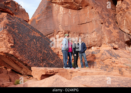 Touristen posieren vor Petroglyphen auf Atlatl großen Felsen Tal des Feuers Staatspark Nevada, usa Stockfoto