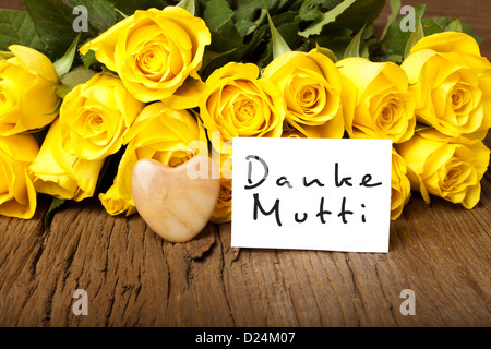 Gelbe Rosen mit steinernen Herzen und eine Karte mit den Worten "Danke Mutti" Stockfoto