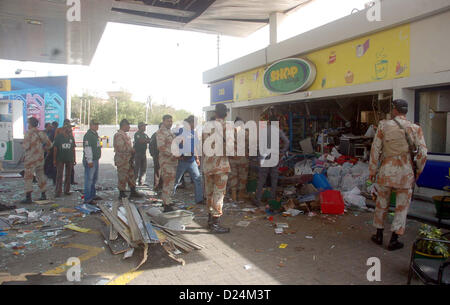 Sicherheitsbeamte und Rettung Freiwilligen versammeln sich am Benzin Bombe nach Explosion an einer Zapfsäule am Khayaban-e-Ittehad im Verteidigungsbereich in Karachi auf Montag, 14. Januar 2013. Quellen zufolge brach Feuer an der Station nach der Explosion, die vier Personen an Khayaban-e-Ittehad Zapfsäule am 10:00 heute verletzt. Drei Verletzte wurden in ein Krankenhaus in der Nähe von Qayyumabad verschoben, während andere mit schweren Verletzungen ins Krankenhaus Jinnah verschoben wurde. Stockfoto