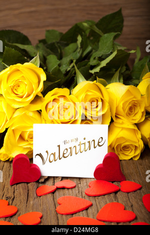 Gelbe Rosen mit vielen roten Herzen und eine Karte mit den Worten "Be my Valentine" Stockfoto