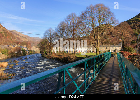 Glaslyn Fußgängerbrücke über Afon Glaslyn River Cottages in malerischen Beddgelert Dorf in Snowdonia Gwynedd North Wales UK Stockfoto