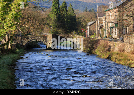 Blick Afon Colwyn Fluss entlang zum alten Bogenbrücke in Beddgelert Dorfzentrum in Snowdonia, Gwynedd, Nordwales, UK, Großbritannien Stockfoto