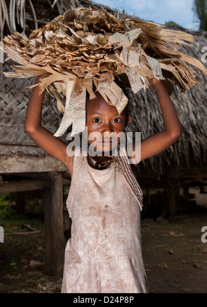 Mädchen halten getrocknete Bananenblätter als lokale Geld, Trobriand Insel, Papua New Guinea Stockfoto