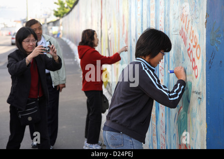 Berlin, Deutschland, asiatischen Besucher an der East Side Gallery Stockfoto