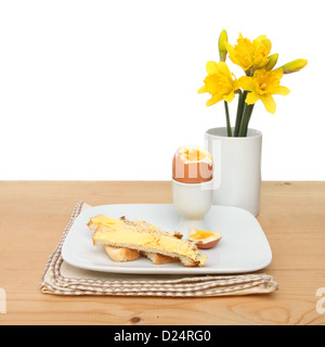 Frühling oder Ostern Themas, gekochtes Ei, Toast Soldaten und Narzisse Blumen auf einem Tisch Stockfoto