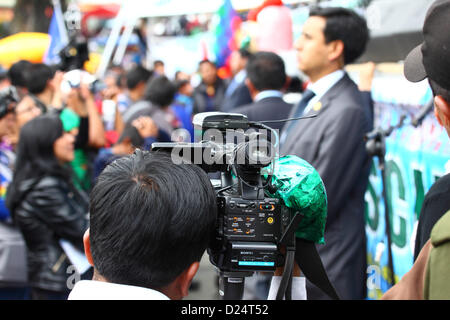 LA PAZ, BOLIVIEN, 14. Januar. Eine Tüte Kokablätter hängt an einer TV-Kamera, während der Kameramann eine Veranstaltung zur Wiedereingliederung Boliviens zum UN-Übereinkommen über Suchtstoffe aus dem Jahr 1961 verfolgt. Bolivien zog sich 2011 förmlich aus dem Übereinkommen zurück und setzte sich dafür ein, dass Klauseln, die die traditionelle Verwendung des Kokablattes verbieten, entfernt werden. Bis zum 11. Januar 2013 hatten nur 15 Länder (weniger als die 62, die zur Blockierung des Vorschlags erforderlich waren) Einwände gegen den Wiedereinstieg Boliviens in das Übereinkommen mit Sonderregelungen erhoben. Stockfoto