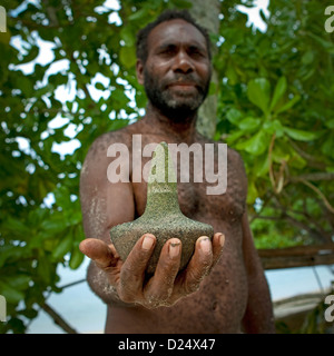 Mann zeigt ein magischer Stein, neues Irland Island, Laraibina Dorf, Papua Neu Guinea Stockfoto