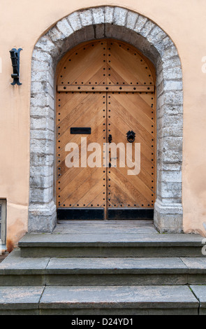 Verstärkte Holztür umgeben von großen Stein mit Stufen zum Eingang in Tallinn Estland Stockfoto