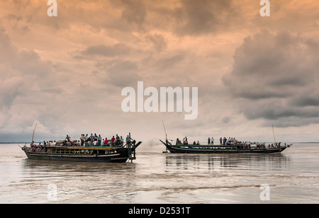 Zwei öffentliche Fähren überqueren den Fluss Brahmaputra bei Sonnenuntergang auf dem Weg zwischen Jorhat und Majuli Insel, Assam Indien. Stockfoto