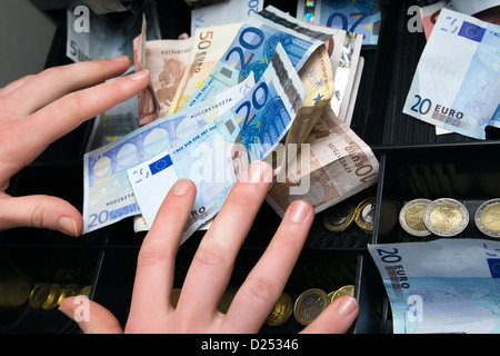 Berlin, Deutschland, Hände für Geld in der Kasse zu erreichen Stockfoto