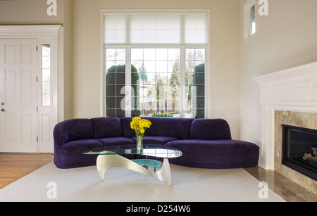 Große Familie Wohnzimmer mit Wildleder Sofa, Glastisch vor großen zweifach verglasten Fenster mit Tageslicht im Raum Stockfoto