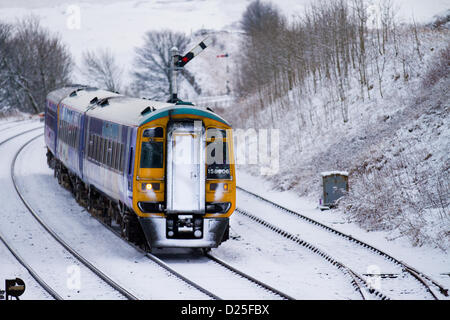 158906 Northern Rail Class 158. Schnee in Kirkby Stephen, Cumbria Januar 2013: Züge, Gleise & Passagiere & Diesel Train nähern sich dem Bahnhof, auf der Siedle Carlisle Railway. Die Eisenbahn arbeitet unter schwierigen Winterbedingungen nach nächtlichem Schneefall und eiskalten Temperaturen. Stockfoto