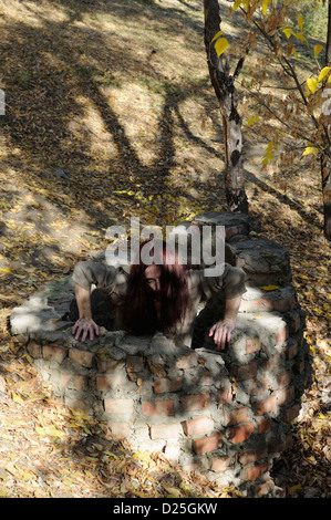 Horror Frau in einem gemauerten Brunnen, kriechen Stockfoto