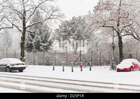 Schneebedeckte Autos an einer ruhigen Straßenecke geparkt nach einem starken Schneefall in Berlin, Deutschland Stockfoto